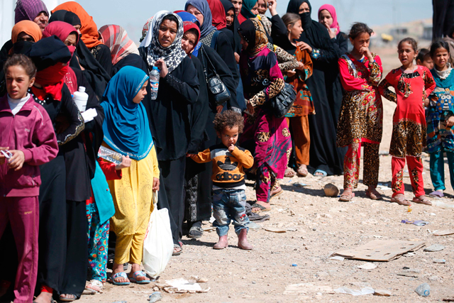 Iraqis, who have fled the city of Mosul due to the ongoing fighting between government forces and Daesh, wait to receive food in the western part of the city on Thursday (AFP photo)