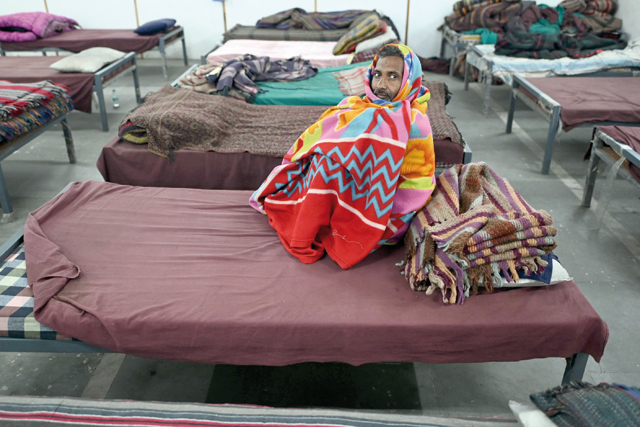 This photo taken on Sunday shows a homeless man wrapped in a quilt sitting inside a government-run shelter in New Delhi (AFP photo)