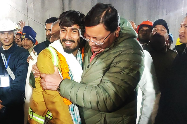 This handout photo released by Uttarakhand’s Department of Information and Public Relation (DIPR) and taken on Tuesday shows Chief Minister of Uttarakhand Pushkar Singh Dhami embracing a contruction worker (AFP photo)