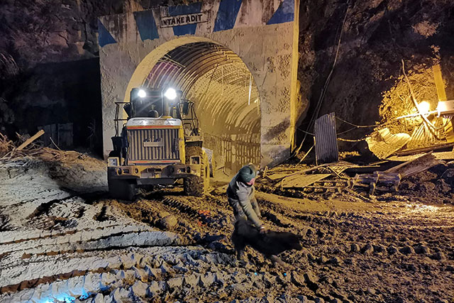 In this photo taken on Monday an Indo-Tibetan Border Police (ITBP) personnel interacts with a stray dog called Blackie near the entrance of Tapovan tunnel, where dozens are still feared to be trapped following a flash flood thought to have been caused when a glacier broke off on Sunday (AFP photo)