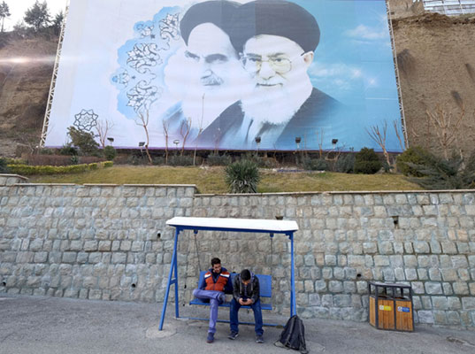 Iranian youths sit under a large picture of Iran's late leader Ayatollah Ruhollah Khomeini (left) and Iran's Supreme Leader Ayatollah Ali Khamenei at a park in Tehran, in this January 17 file photo (Reuters photo)