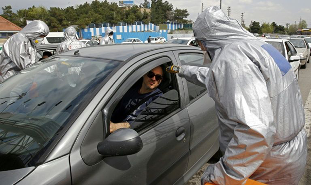 Red Crescent members test people for coronavirus symptoms, as Iranian police blocked Tehran to Alborz highway to check every car (AFP photo )
