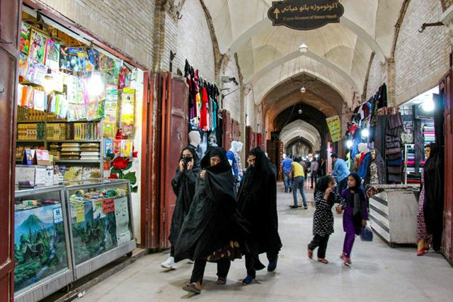 Iranians walk past shops in the southeastern city of Kerman amid the coronavirus pandemic (AFP photo)