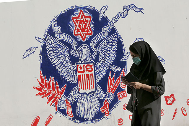 An Iranian woman walks past a mural painted on the outer walls of the former US embassy in the Iranian capital Tehran, on Wednesday (AFP photo)