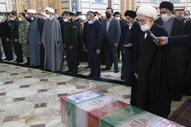 This handout photo provided by Iran's defence ministry on Sunday shows mourners praying by the coffin of Iran's assassinated top nuclear scientist Mohsen Fakhrizadeh during his funeral procession at Fatima Masumeh's Shrine in Qom, south of Tehran (AFP photo)