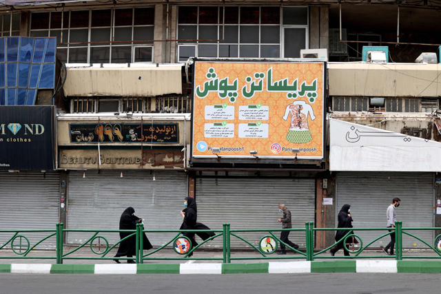 Iranians walk past closed shops in the capital Tehran, on Sunday, following the tightening of restrictions to curb the surge of COVID-19 cases (AFP photo)
