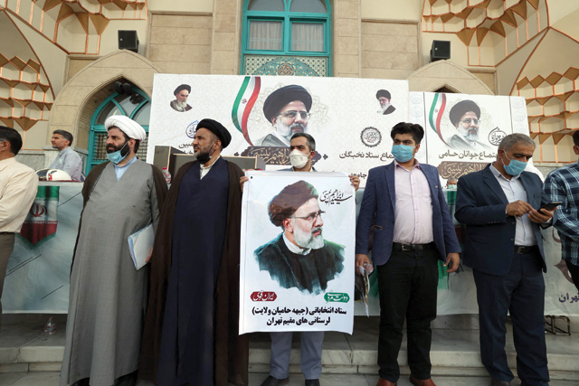 Clerics and supporters of Iranian ultraconservative presidential candidate Ebrahim Raisi carry his portrait during a rally in the capital Tehran, on Wednesday, ahead of the Islamic republic’s Friday’s presidential election (AFP photo)
