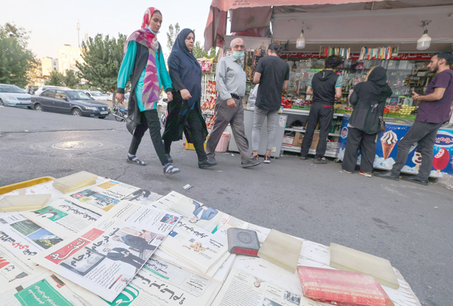 Iranians walk past a newspaper stall in the capital Tehran on Tuesday (AFP photo)
