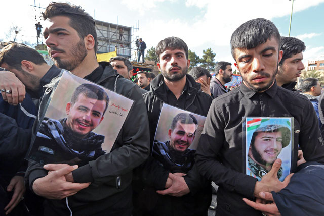 Iranian men hold portraits of their relatives, members of Revolutionary Guard who were killed in a suicide attack, in southeastern city of Isfahan, on Saturday (AFP photo)