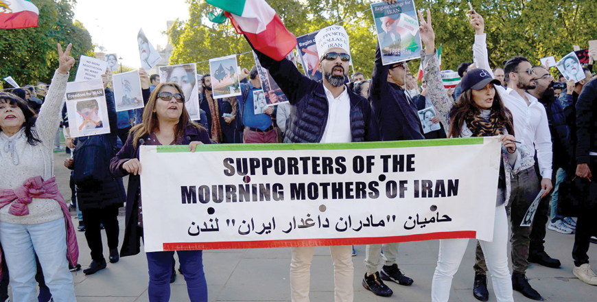 People chant slogans and hold the photos of Mahsa Amini during a demonstration in central London on Saturday (AFP photo)