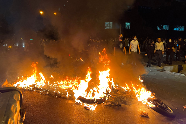 A file photo obtained by AFP outside Iran shows demonstrators gathering near a motorbike on fire during a protest for Mahsa Amini, a woman who reportedly died after being arrested by the Islamic republic’s ‘morality police’, in Tehran on September 19, 2022 (AFP photo)