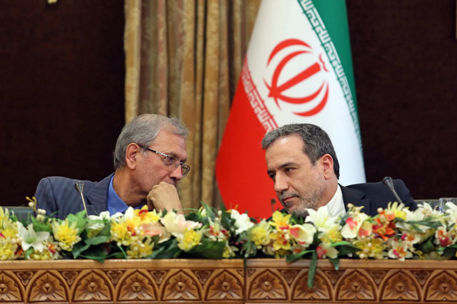 This handout photo provided by the Iranian presidency shows Iran's government spokesman Ali Rabiei (left) and Deputy Foreign Minister Abbas Araghchi speaking to each other during a joint press conference at the presidential headquarters in the capital Tehran on Sunday (AFP photo)