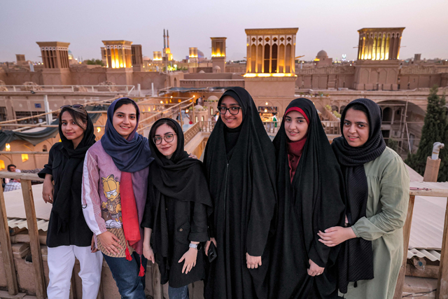 Women pose for a group photo with wind catchers (‘badir’ in Persian) dotting the skyline behind, on a rooftop in Iran’s central city of Yazd, on July 3 (AFP photo)