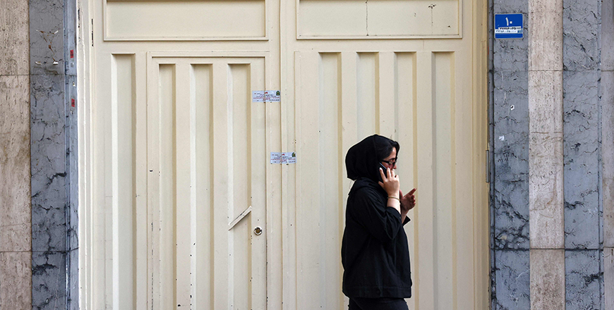A woman speaks on a phone as she walks past the closed gate of the Tehran offices of Germany's Goethe-Institut cultural centre on August 20 (AFP photo)