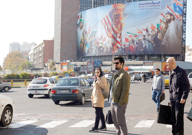 Iranian pedestrians cross a street at Valiasr Square in Tehran on Thursday  (AFP photo)