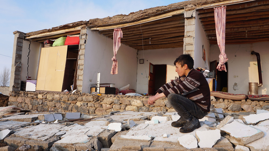 A Turkish child kneels by a destroyed house in Baskale, in the Van province, after a magnitude 5.7 earthquake in northwestern Iran killed at least nine people in neighbouring Turkey and injured dozens more on both sides of the border (AFP photo)