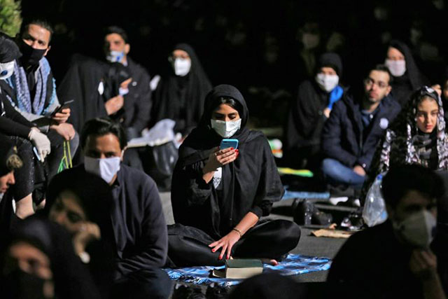 Iranians, some wearing face masks against the coronavirus, attend prayers outside a Tehran mosque on one of the holiest nights of the Muslim fasting month of Ramadan (AFP photo)