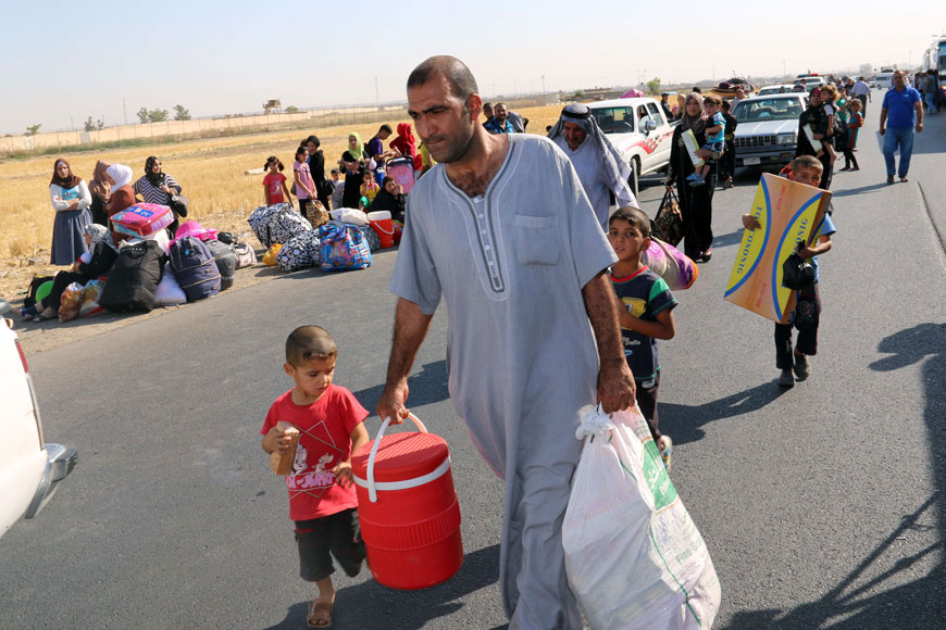 Displaced Iraqis carry their belongings before boarding vehicles to return home to the city of Tikrit, in areas that were retaken by security forces and pro-government fighters from the Daesh group, on Tuesday at a gathering point in the northern city of Kirkuk. Iraqi forces retook the city of Tikrit from Daesh group in April, in Baghdad’s biggest victory to date over militants who overran large parts of the country last June (AFP photo)