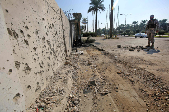 A member of the Iraqi security forces inspects the damage outside the Zawraa park in the capital Baghdad on Wednesday, after volley of rockets slammed into the Iraqi capital breaking a month-long truce on attacks against the US embassy (AFP photo)