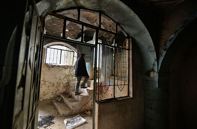 An Iraqi man walks inside a heavily damaged house in the Old City of Mosul on Tuesday (AFP photo)