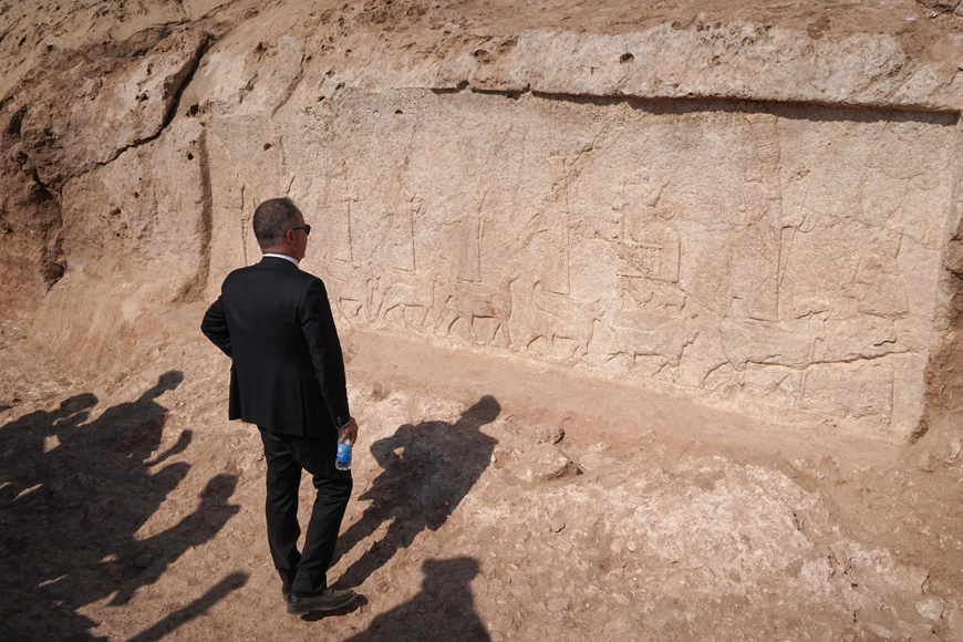Italian Ambassador to Iraq Maurizio Greganti looks at a carved plaque lining an ancient irrigation canal dating back to Assyrian times, in the archaeological site of Faydeh (Faida) in the mountains near the town of the same name, in the autonomous Kurdish region of Iraq, on Sunday (AFP photo)