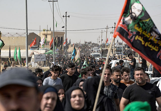 Iraqi pilgrims walk towards the shrine of Imam Zayn Al Abidin, the fourth Imam of Shiite Muslims and great grandson of Prophet Mohammad, in the northern city of Mosul, on the tenth day of the month of Muharram which marks the peak of Ashura, on Thursday (AFP photo)