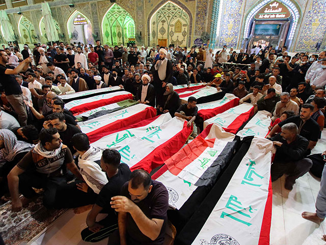 Mourners on Wednesday, surround the caskets of victims of yesterday's attack on the village of Al Rashad in Iraq's eastern Diyala province that reportedly killed at least 11 people (AFP photo)