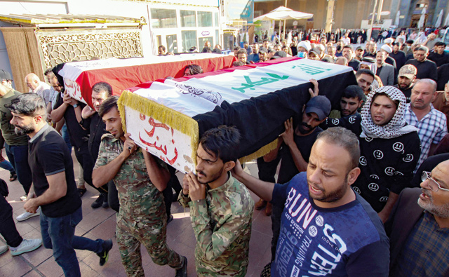 Iraqis carry the coffins of two supporters of the Hashed Al Shaabi, who the paramilitary network says died a day earlier amid clashes with security forces while protesting in the capital to express rejection of last month’s election results, during their funeral in the central holy shrine city of Najaf on Saturday (AFP photo)