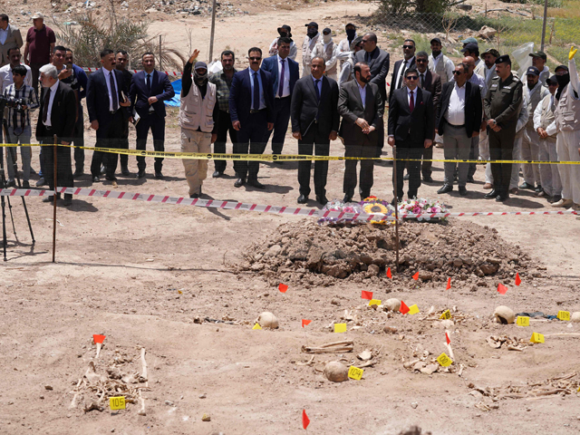 Iraqi officials visit a mass grave where human remains were exhumed by the country’s authorities, near the southern city of Najaf, on Saturday (AFP photo)