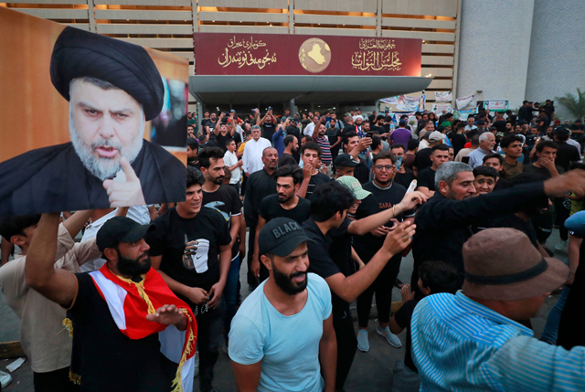 Supporters of Iraqi Shiite cleric Moqtada Al Sadr gather during a protest against the nomination of a rival Shiite faction for the position of prime minister, outside the Iraqi parliament building in the Green Zone in the capital Baghdad on Tuesday (AFP photo)
