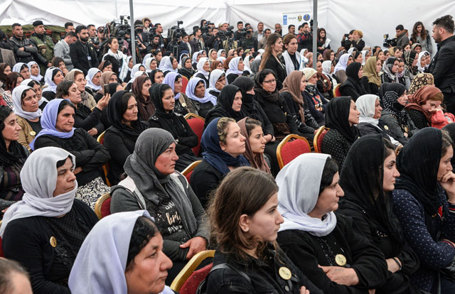 Iraqi Yazidi women attend the exhumation of a mass grave of hundreds of Yazidis killed by Daesh group militants in the northern Iraqi village of Kojo in Sinjar district on Friday (AFP photo)