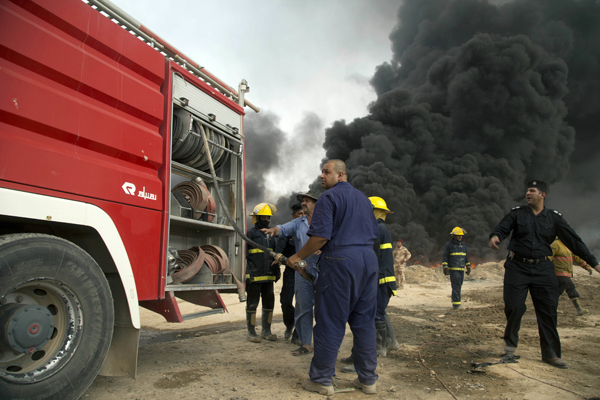 In this Wednesday photo, Iraqi firefighters battle large fire at oil wells as they are trying to prevent the flames from reaching the residential neighbourhoods in Qayyarah, Iraq (AP photo)