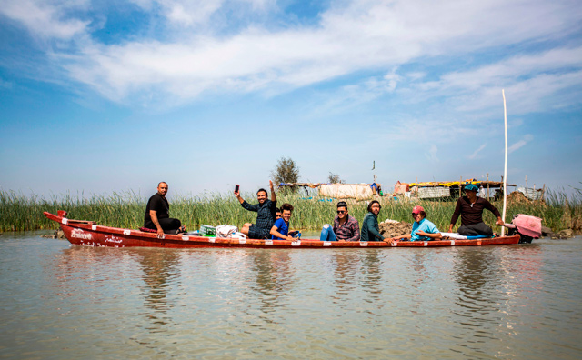 Tourists sit in a canoe as they are shown around the marshes of the southern Iraqi district of Chibayish in Dhi Qar province, about 120 kilometres northwest of the southern city of Basra, on March 29  (AFP photo)