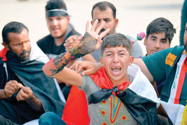 An Iraqi teeanager, who apparently lost four friends in recent protests, cries as he joins the latest anti-government demonstration outside the Najaf governorate headquarters in the central shrine city on Sunday (AFP photo)