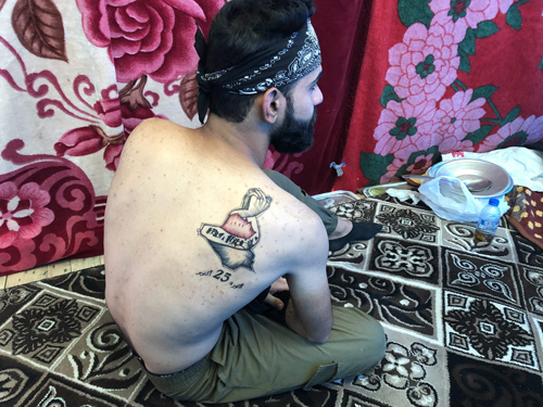 An Iraqi man displays his tattoo in the capital Baghdad on December 9 (AFP photo)