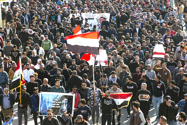 Iraqis carry mock coffins as they take part in a rally on Saturday, to mourn two reporters shot dead the previous evening in the country's southern city of Basra, where they had been covering months of anti-government protests (AFP photo)