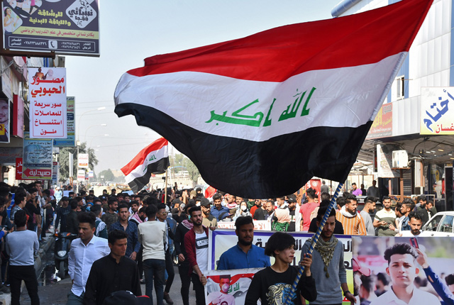 Student protesters march with Iraqi national flags during an anti-government demonstration in the southern city of Nasiriyah, in Dhi Qar province, on Sunday  (AFP photo)