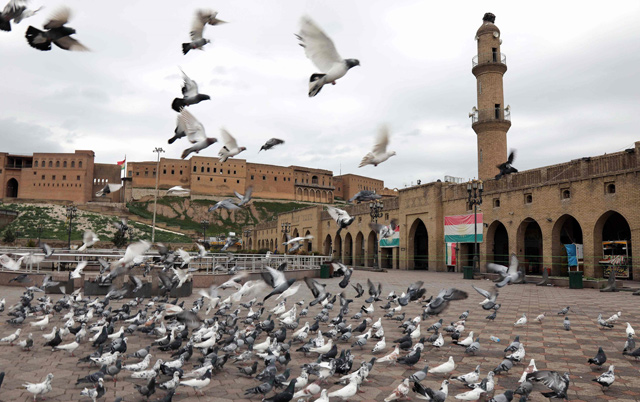 Pigeons flutter in front of the Erbil citadel during the first day of lockdown in the capital of the northern Iraqi Kurdish autonomous region on Saturday (AFP photo)