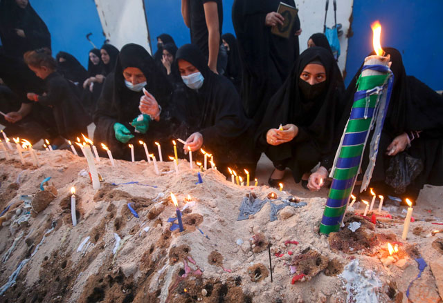 Iraqi women light candles during a memorial ceremony on the tenth day of the month of Muharram which marks the peak of Ashura, in the holy city of Karbala, on Sunday (AFP photo)