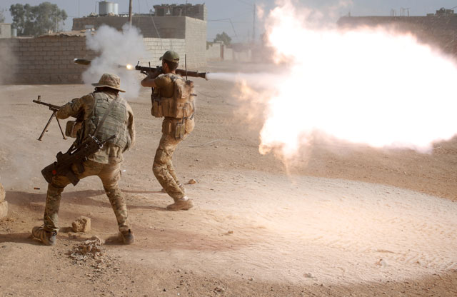 Members of an Iraqi special forces police unit fire their weapons at Daesh militants in Al Shura, south of Mosul, Iraq, on Saturday (Reuters photo)