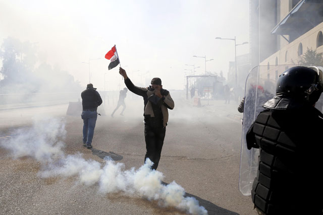 Protesters clash with security forces during a rally to demand the dissolution of Iraq’s high electoral commission, next to the Green Zone where governmental buildings are located, in Baghdad on Saturday (Anadolu Agency photo)