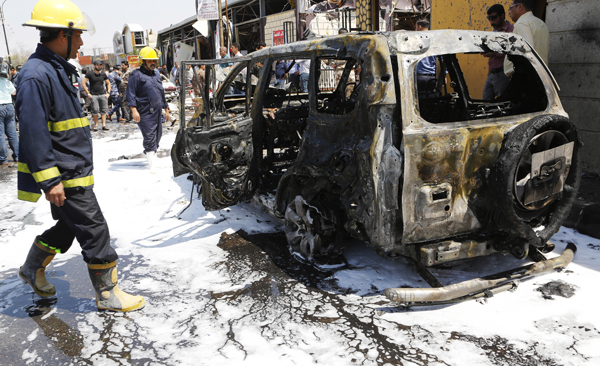 Iraqi security forces inspect the scene of a suicide car bomb attack in Basra, Iraq's second-largest city, 550 kilometres southeast of Baghdad, Iraq, on Monday (AP photo)