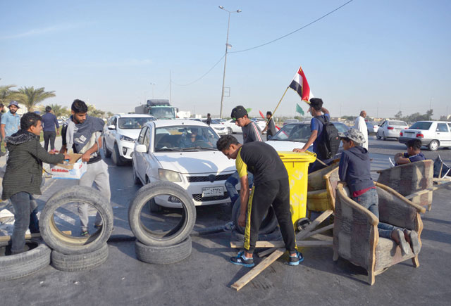 Iraqi protesters use tyres to block the road to Najaf Airport during continuing anti-government protests in the central Iraqi holy city on Wednesday (AFP photo)
