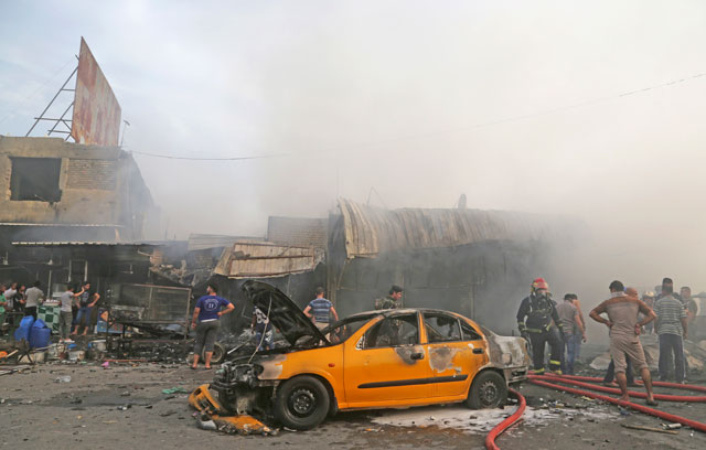 Iraqi firefighters extinguish a fire following a suicide bomb attack in the capital’s eastern Shiite-dominated new Baghdad neighbourhood, Iraq, Monday (AP photo)