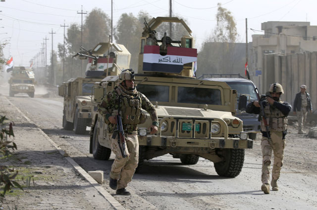 Iraqi soldiers run during a battle against Daesh militants in the Wahda district of eastern Mosul, Iraq, on Tuesday (Reuters photo)