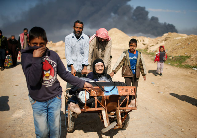 Displaced Iraqis flee their homes as Iraqi forces battle with Daesh militants in western Mosul, Iraq, on Tuesday (Reuters photo)