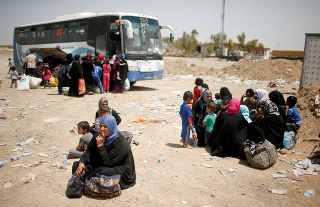 Displaced Iraqis wait to move to a safe place as Iraqi forces battle with Daesh militants, in western Mosul, Iraq, on Wednesday (Reuters photo)