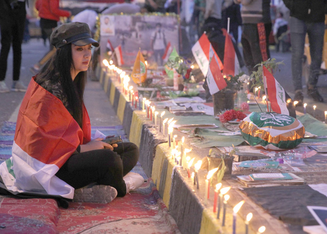 Iraqi anti-government protesters hold a candlelight vigil in Baghdad's Tahrir Square on Thursday for comrades killed in demonstrations against corruption, unemployment and an out-of-touch political class (AFP photo)