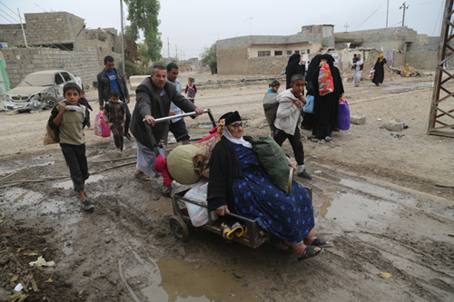 Iraqi civilians with their belongings arrive at Tahrir neighbourhood, controlled by Iraqi security forces, on Wednesday as operation to retake Mosul from Daesh militants continues (Anadolu Agency photo)