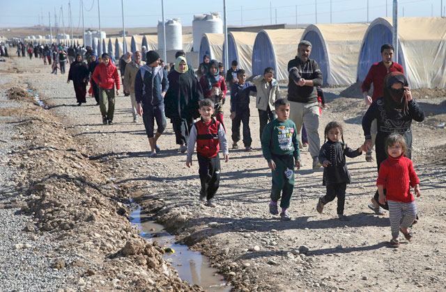 Iraqi citizens, who fled the fighting between Daesh militants and the Iraqi forces, walk inside a camp for internally displaced people in Khazer, east of Mosul, Iraq, on Monday (AP photo)